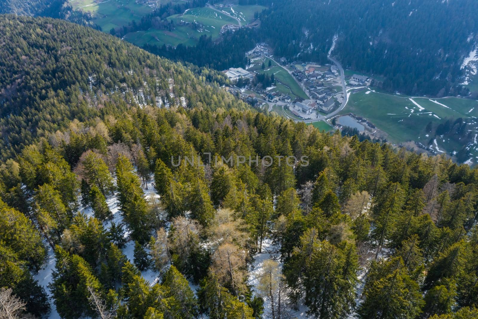 Aerial view of huge valley of the mountains of Italy, Trentino, green meadows, Slopes with green spruce trees, Dolomites on background, The town in the bottom of a valley by vladimirdrozdin