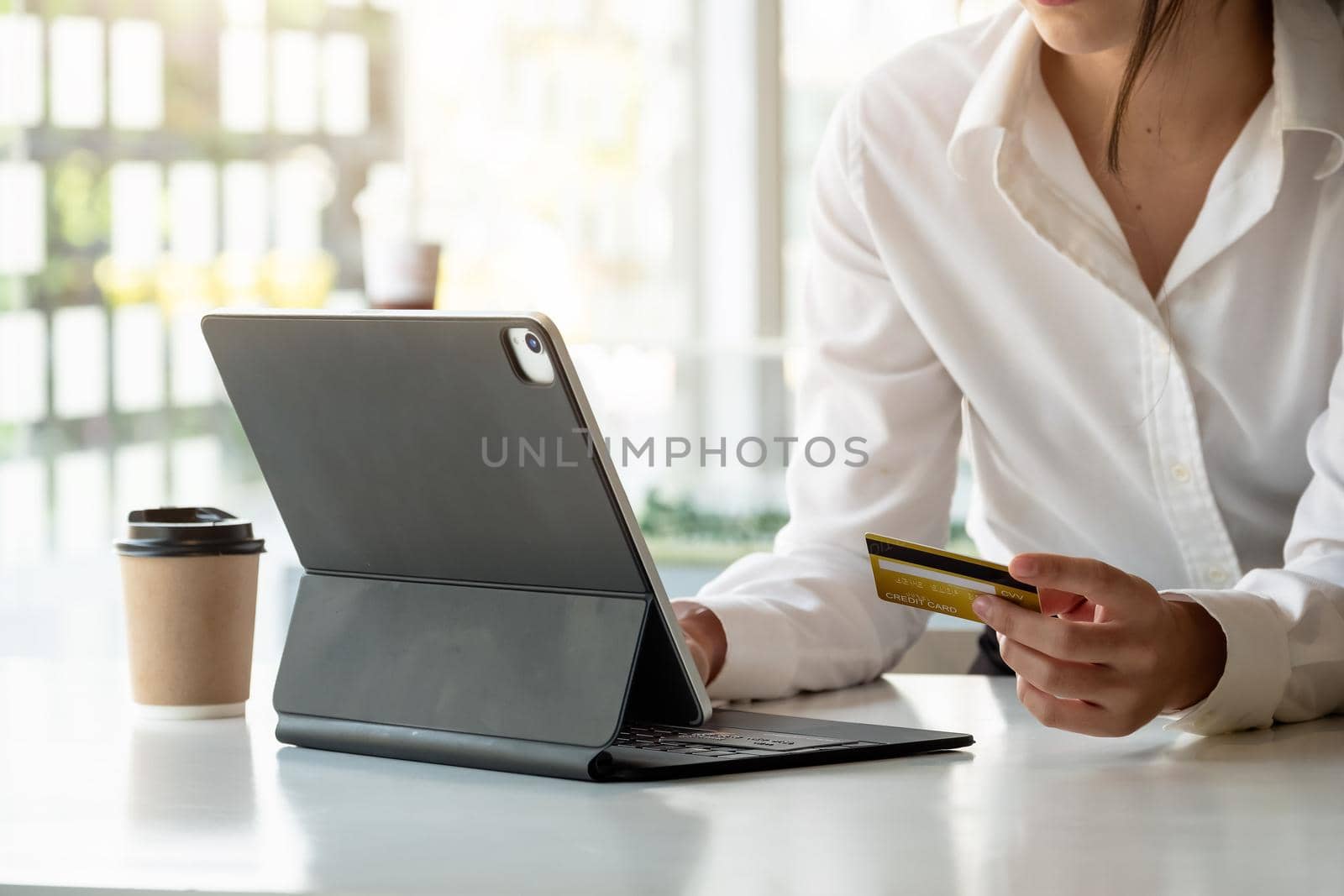 girl makes a purchase on the Internet on the smart tablet with credit card - online shopping concept