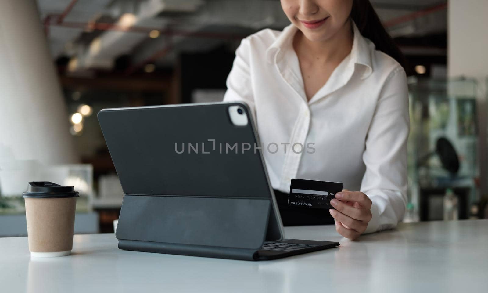girl makes a purchase on the Internet on the smart tablet with credit card - online shopping concept