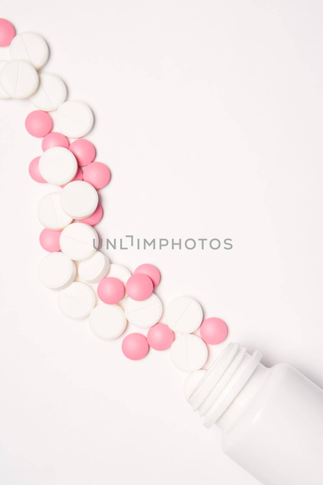 White jar with pills on a light background top view medicine health vitamins. High quality photo
