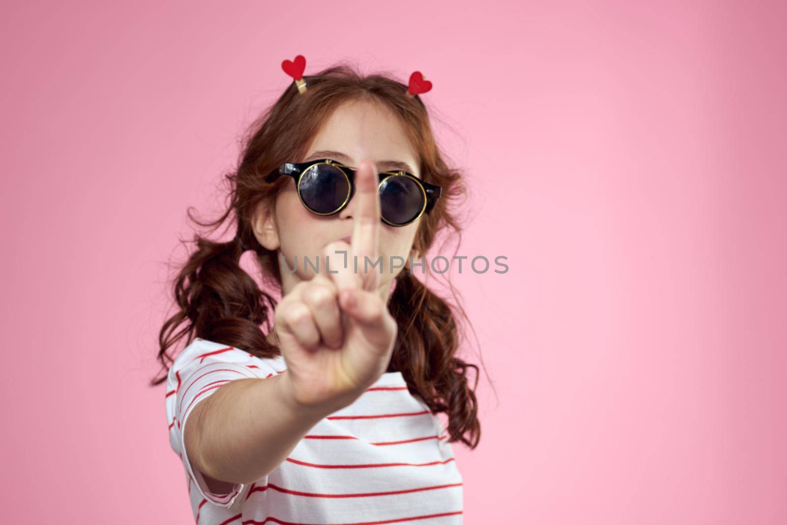 Fashionable girl with clothespins in the form of hearts on her head and glasses on her face by SHOTPRIME