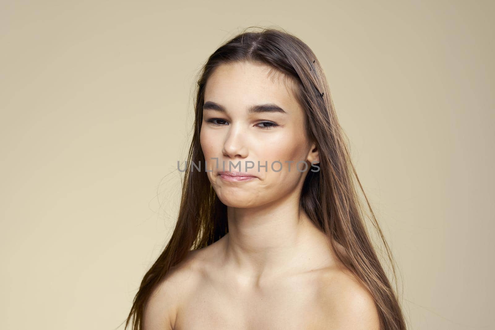 Pretty woman naked shoulders long hair body care beige background by SHOTPRIME