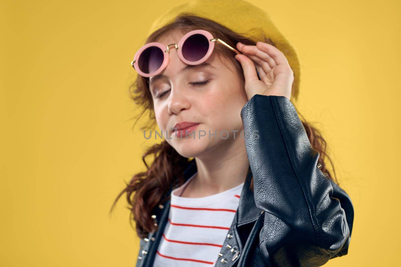 Girl in a yellow hat dark glasses fashionable clothes studio lifestyle childhood. High quality photo