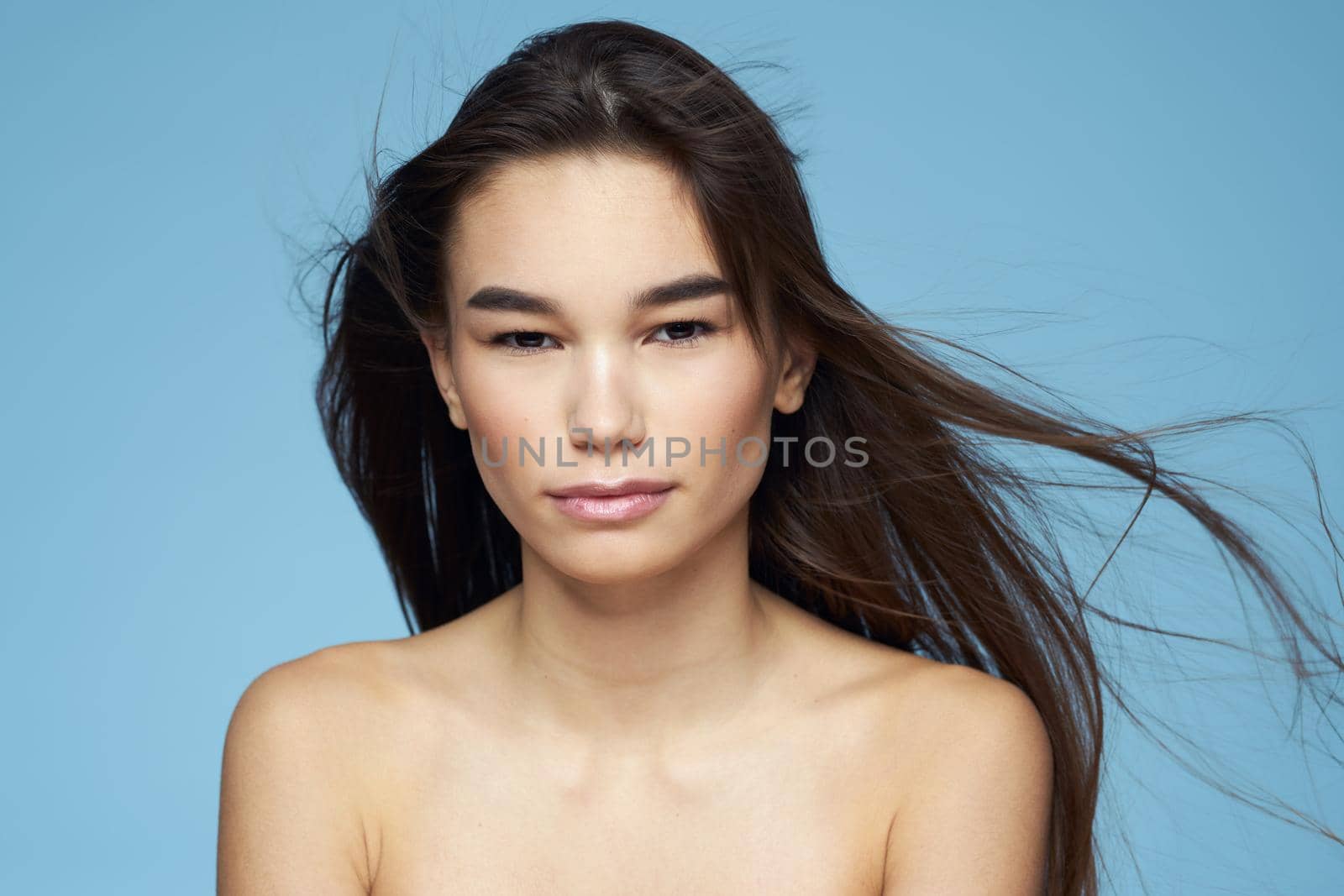 Pretty woman naked shoulders hair care close-up bank blue background by SHOTPRIME