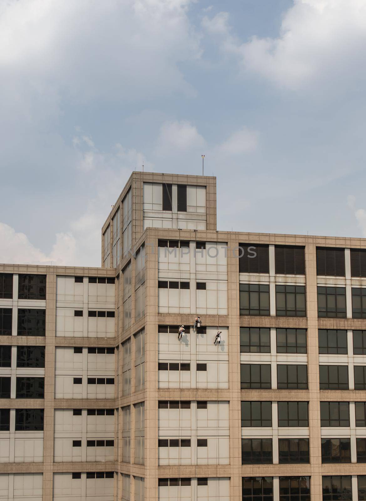 Group of workers cleaning windows service on high rise office building. Selective focus.