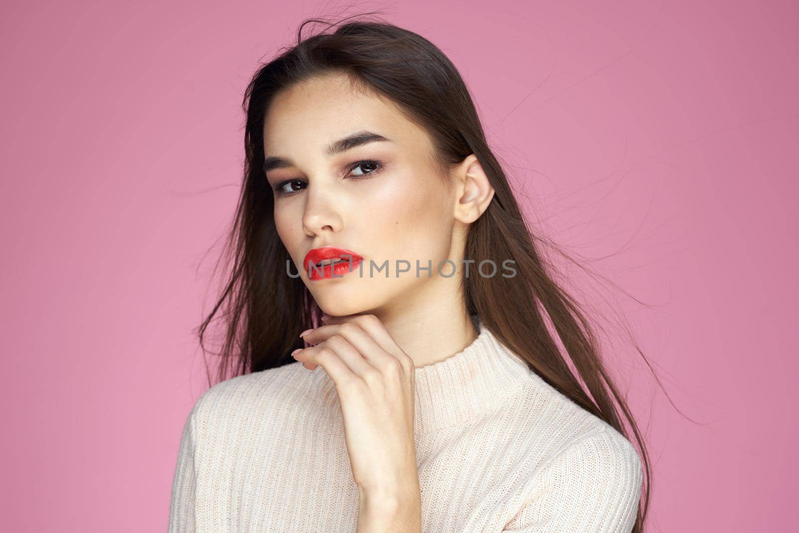 Beautiful brunette red lips white blouse close-up attractive view pink background. High quality photo