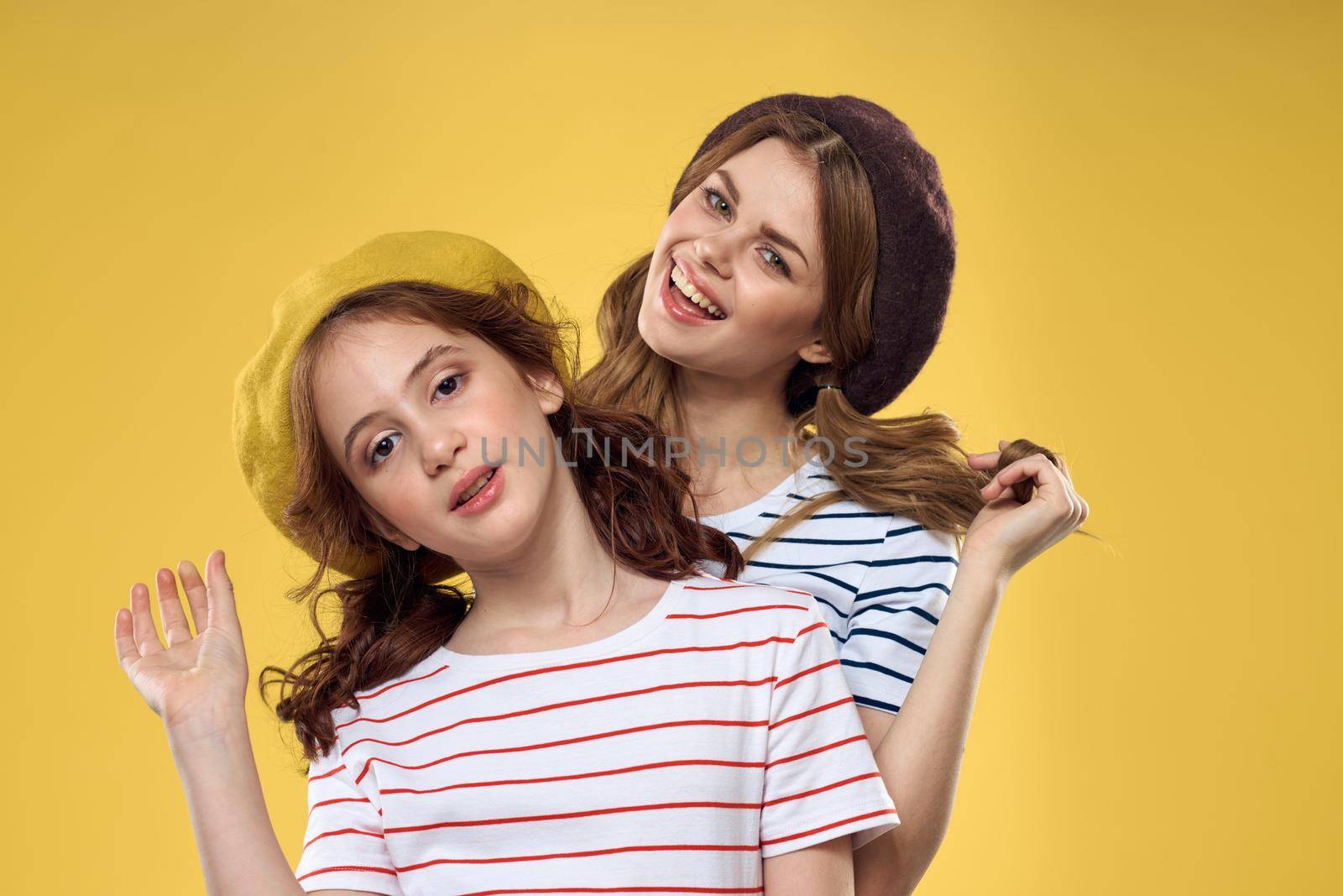 Mom and daughter embrace joy fun childhood lifestyle yellow background. High quality photo
