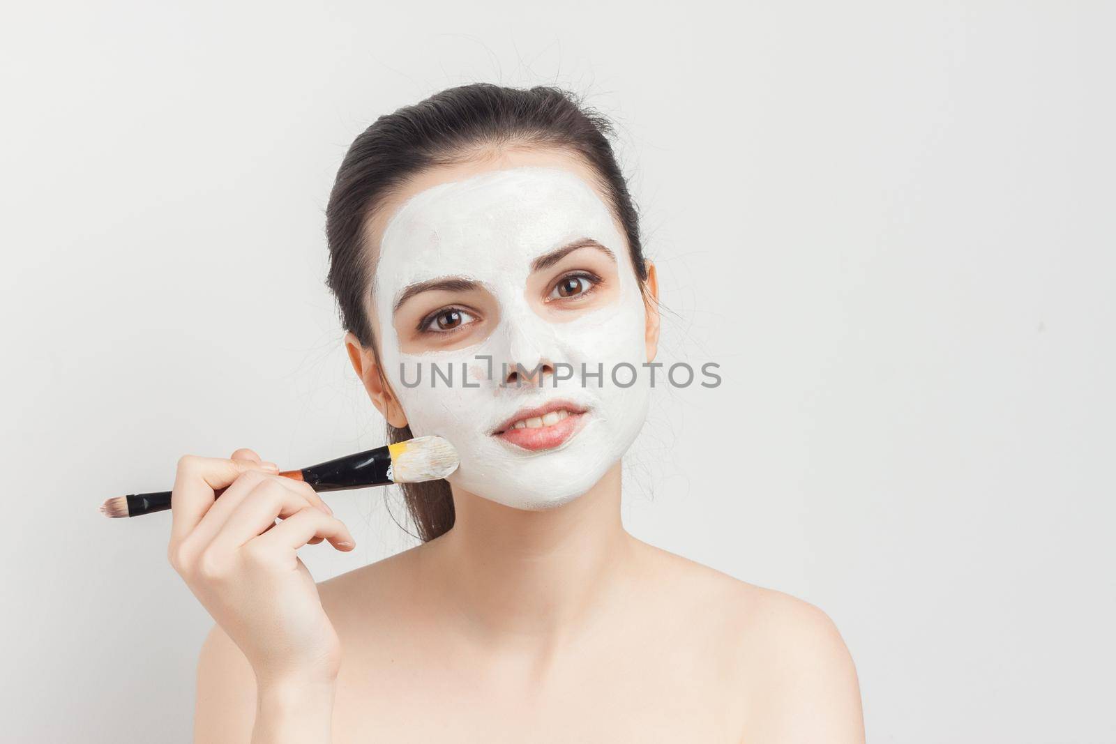 woman with bare shoulders apply brush face mask skin care spa treatments by SHOTPRIME