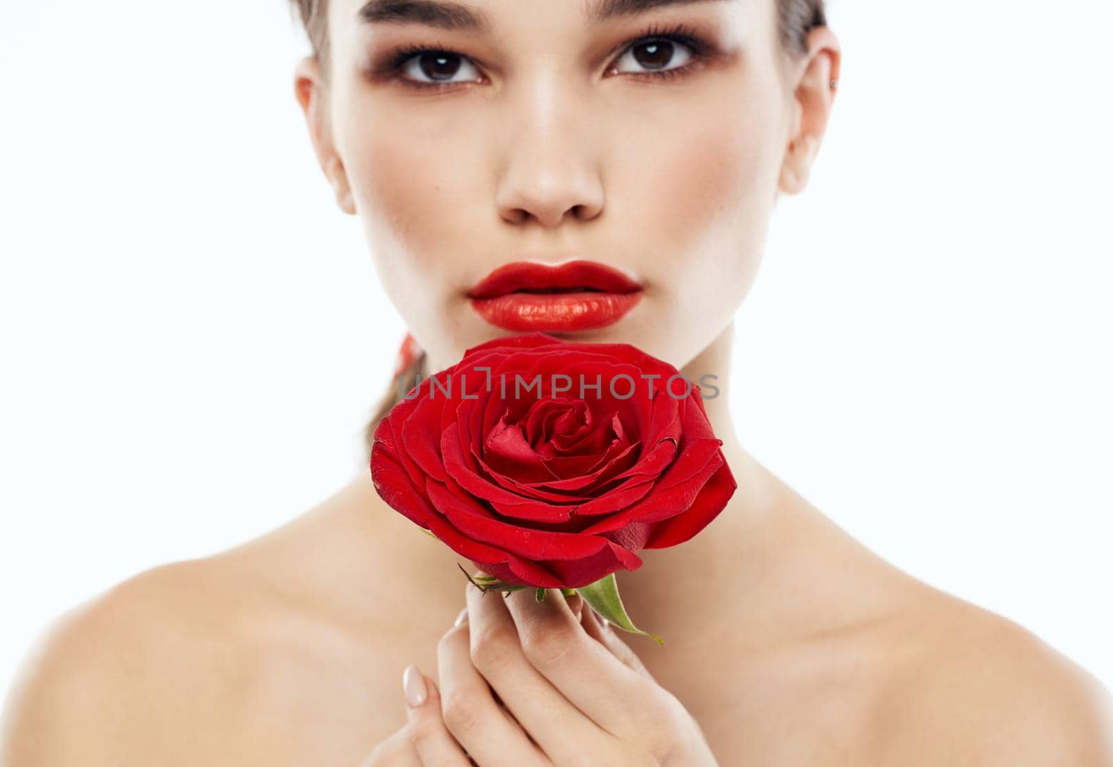 Portrait of romantic people with bare shoulders and a red flower in front of their eyes by SHOTPRIME