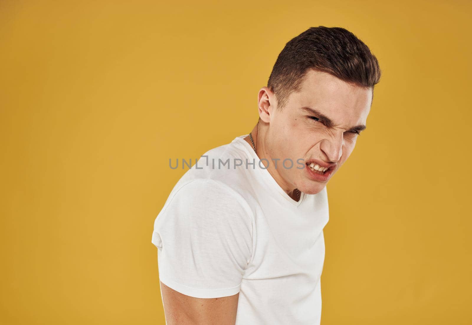 Side view of a man in a white T-shirt on a yellow background by SHOTPRIME