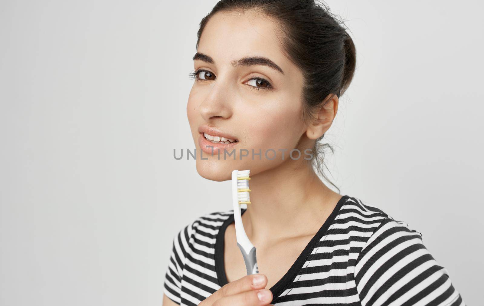 cheerful woman in striped t-shirt toothbrush hygiene by SHOTPRIME
