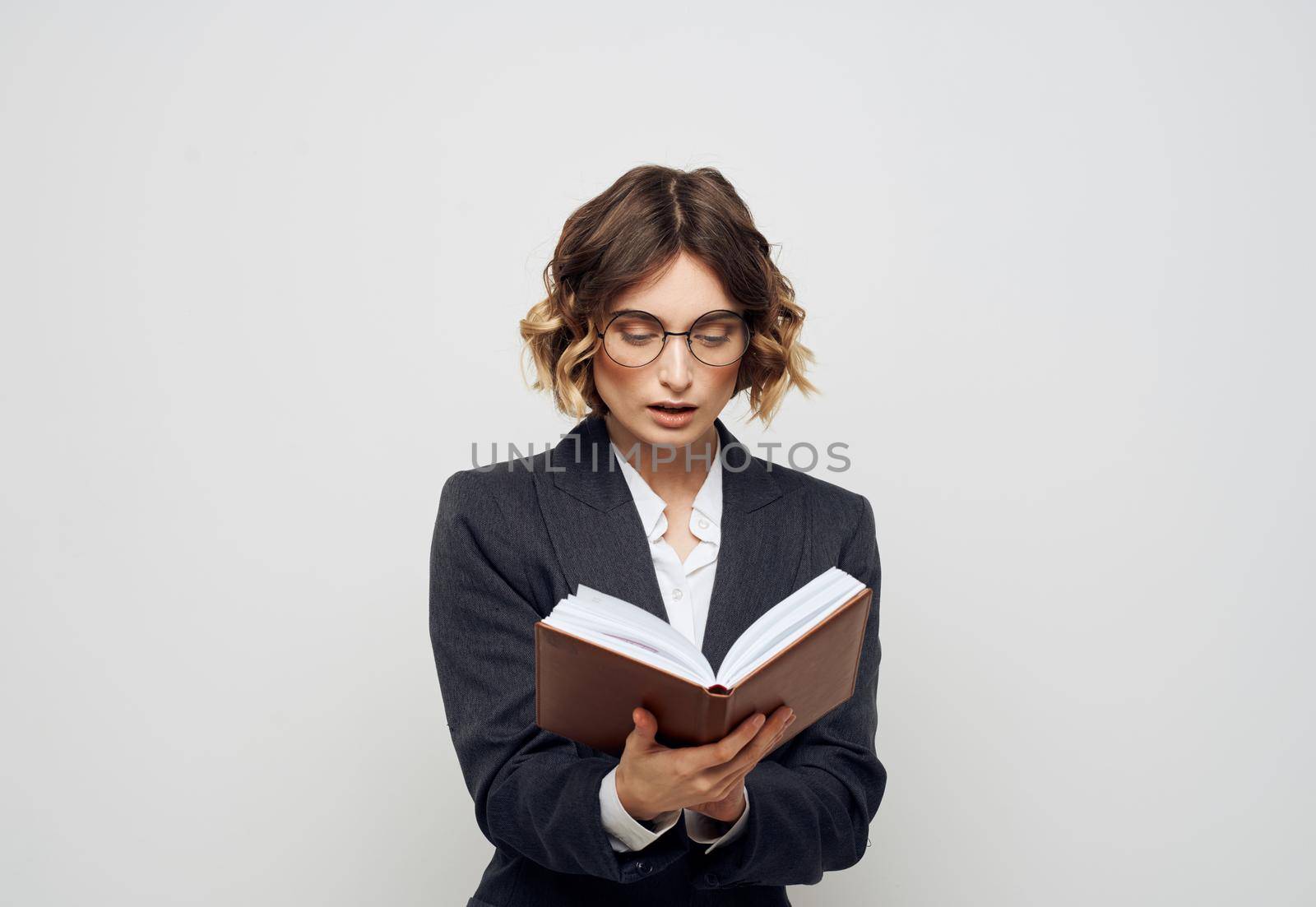 Woman in classic suit with open book glasses on face cropped view. High quality photo