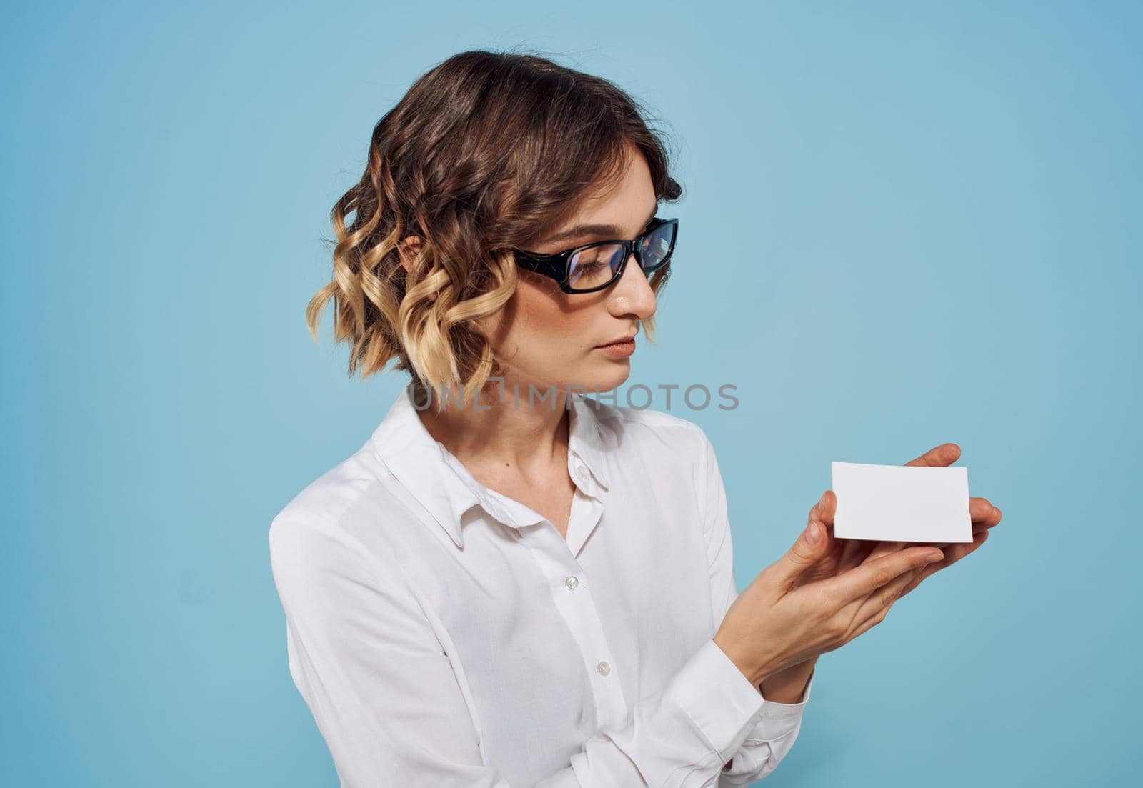 woman with white letterhead in hands shirt glasses hairstyle blue background. High quality photo