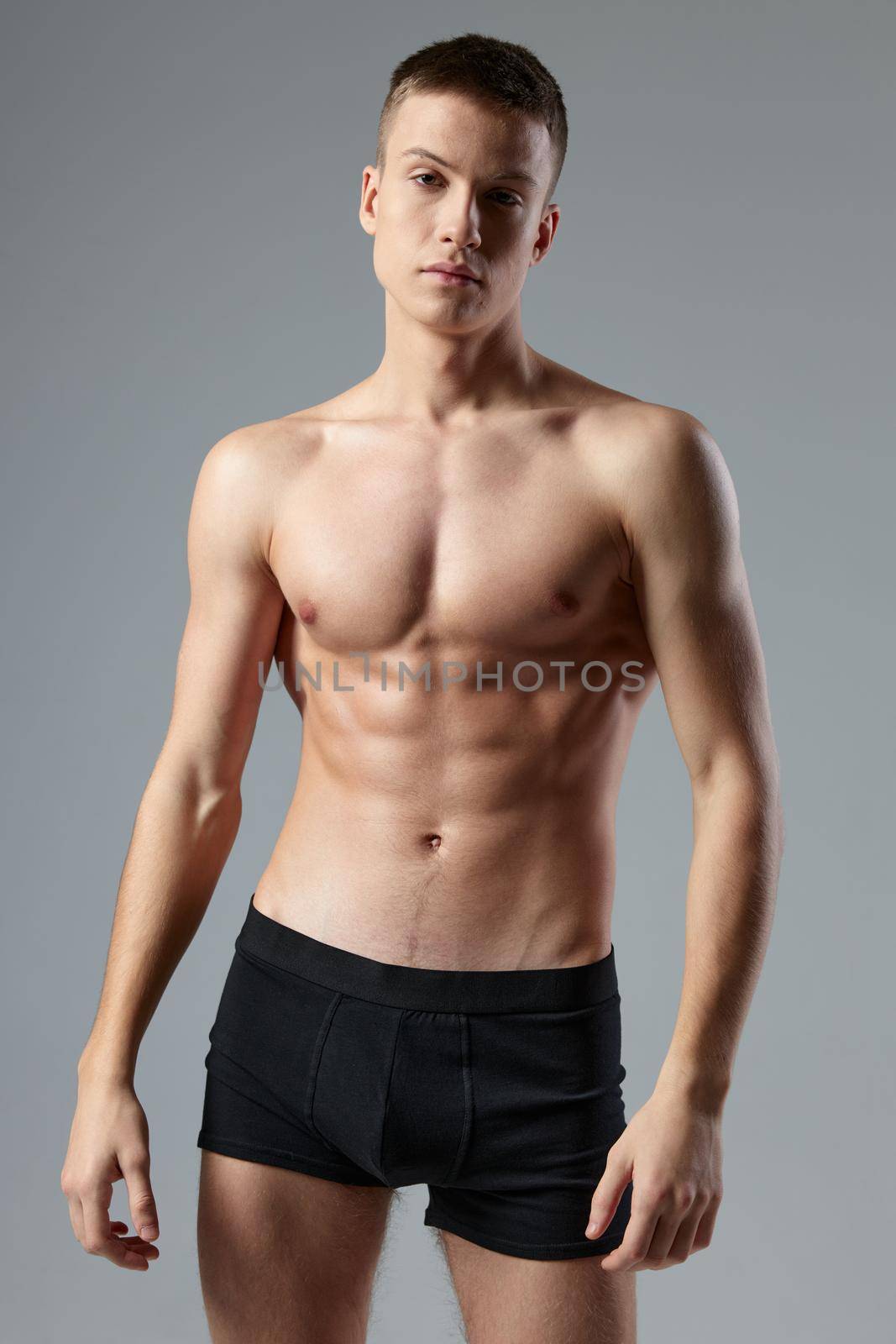 athletic male bodybuilder with pumped up abs black panties cropped view studio. High quality photo