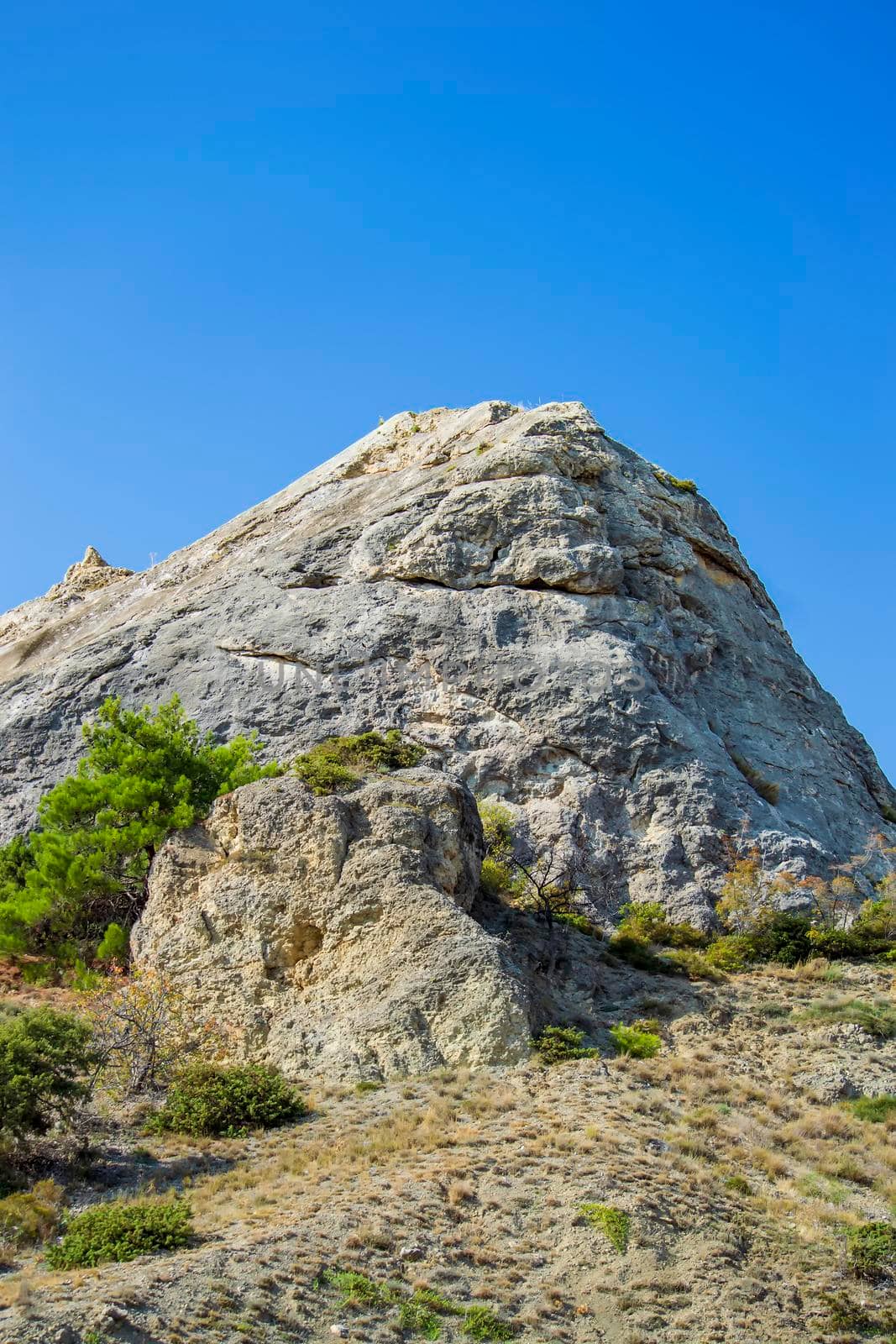 Rock and vegetation are scarce in Crimea against clouds and sky. by Essffes