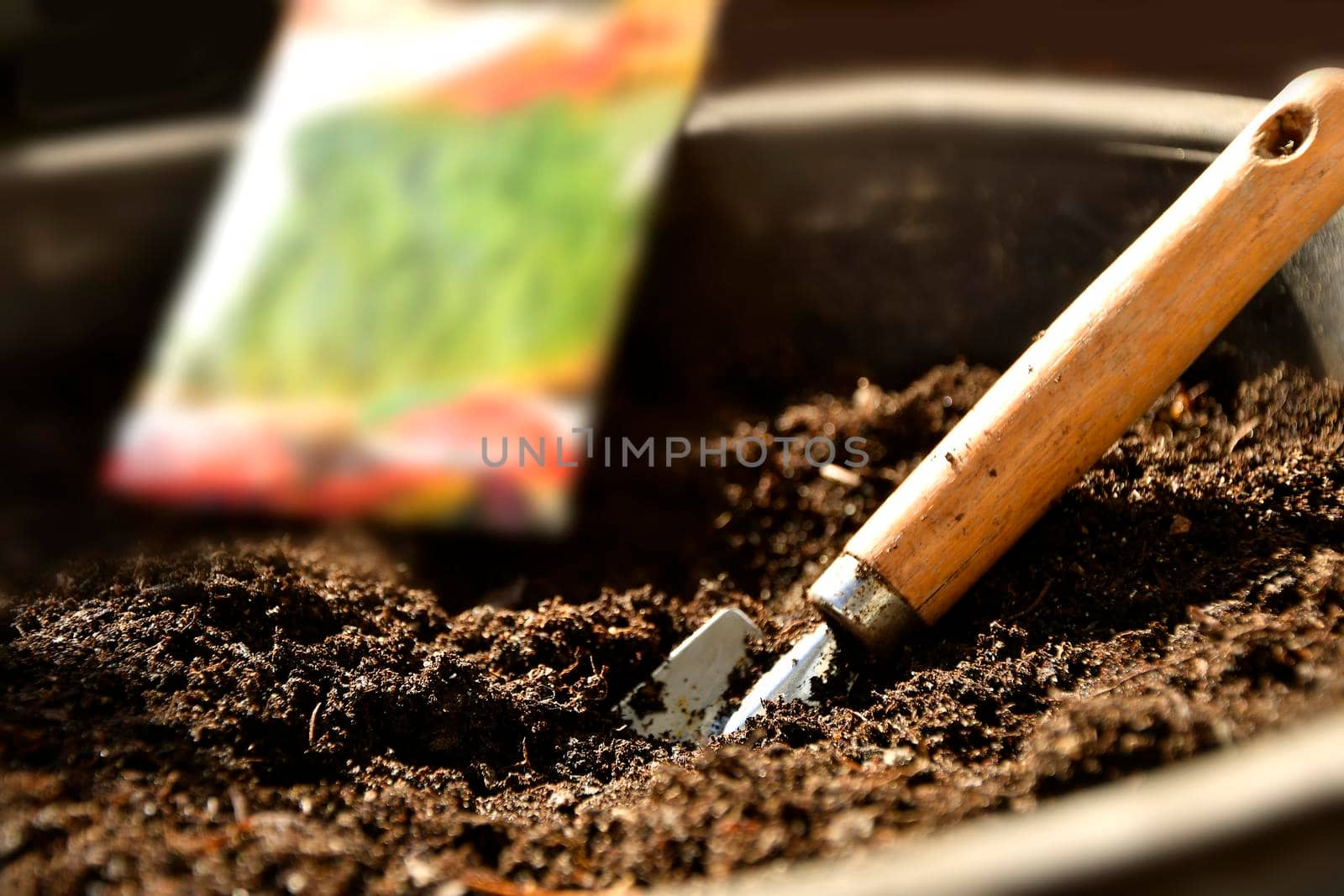 shovel in a pot with earth and seed packet by Jochen