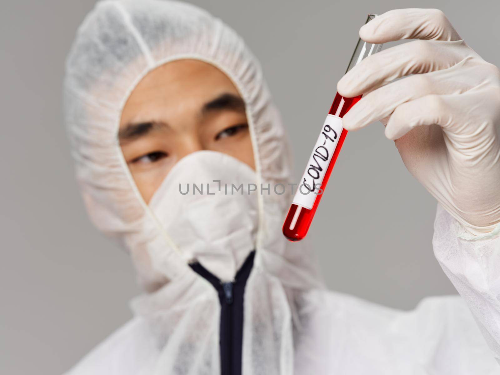 Male laboratory assistant Asian appearance blood tests for covid-19 close-up. High quality photo
