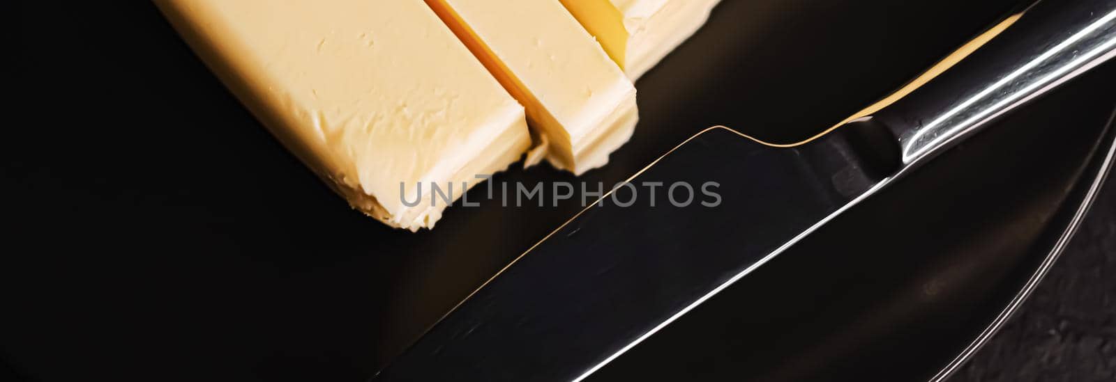 Sliced organic butter block and knife, breakfast food closeup