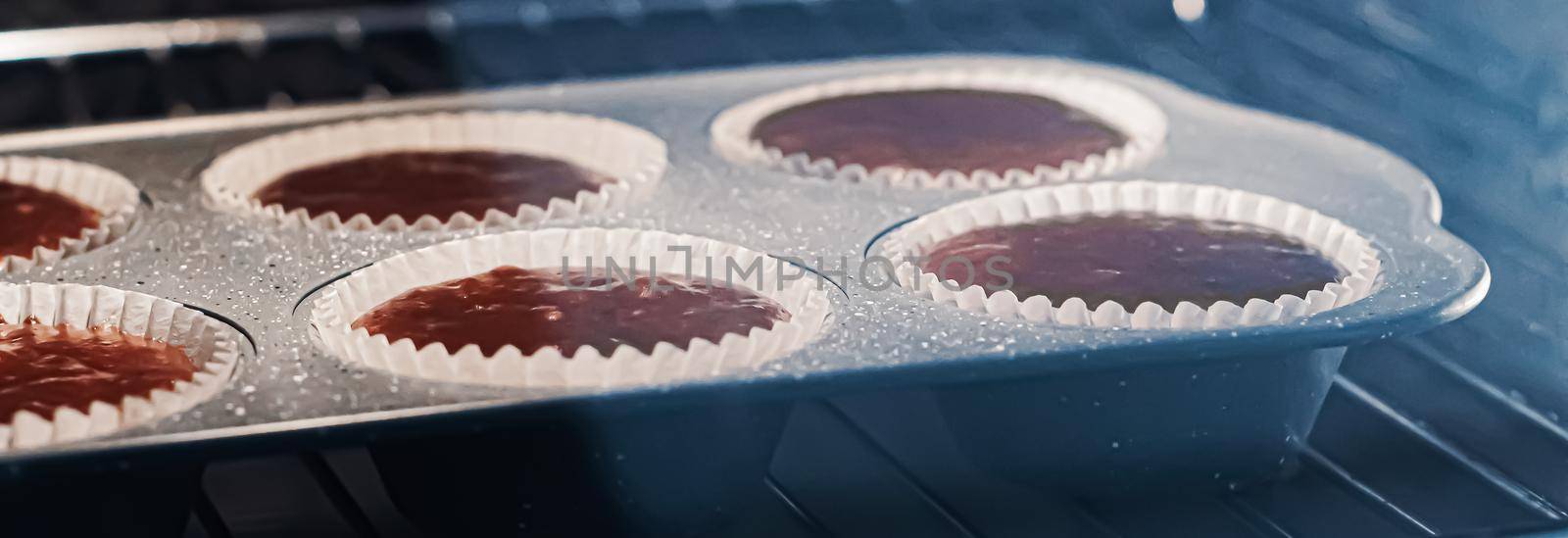 Chocolate muffins baking in the oven, homemade comfort food recipe by Anneleven