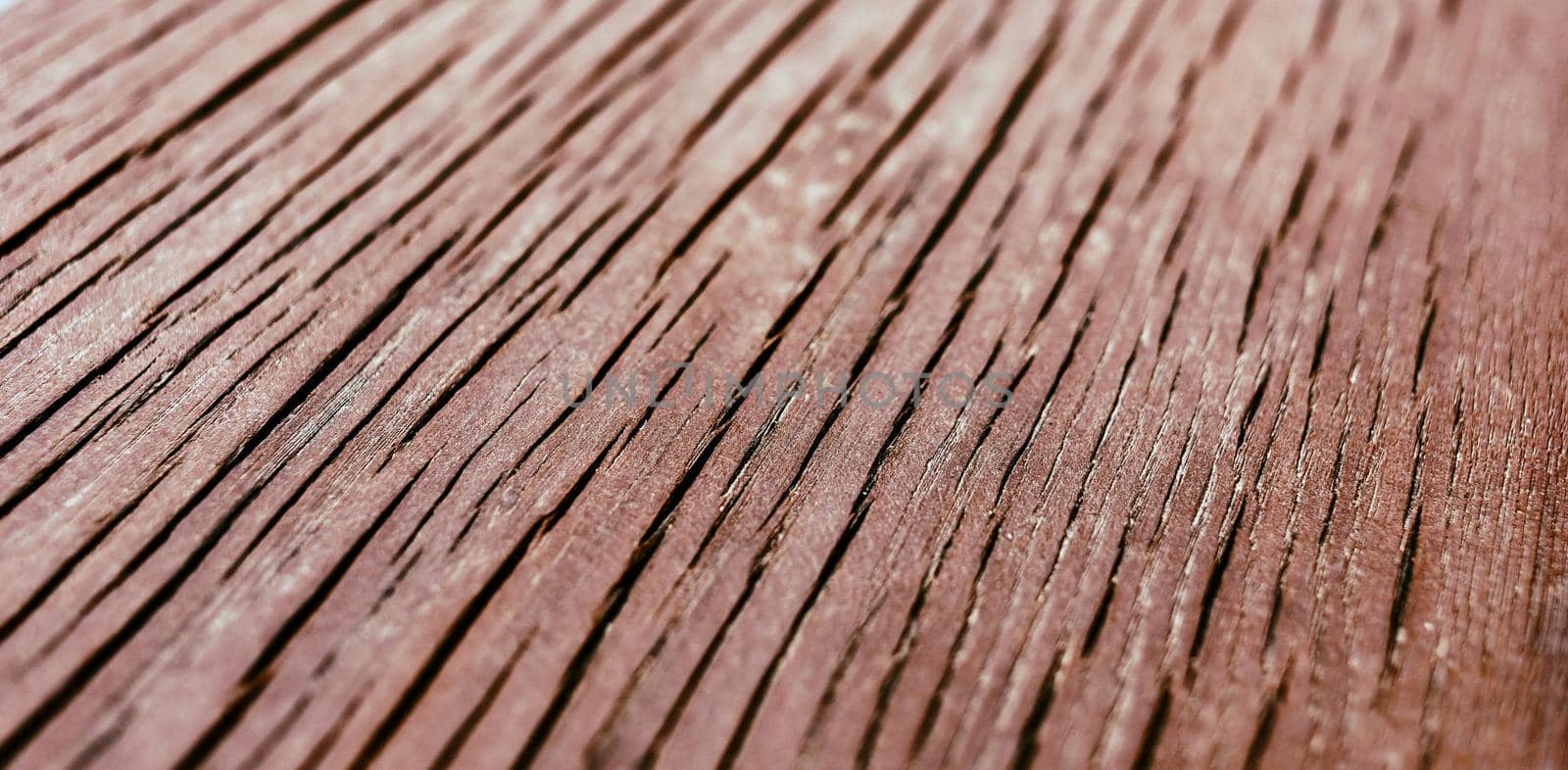 Wooden surface of the table with deep cracks. Close-up of an old cracked board with deep cracks