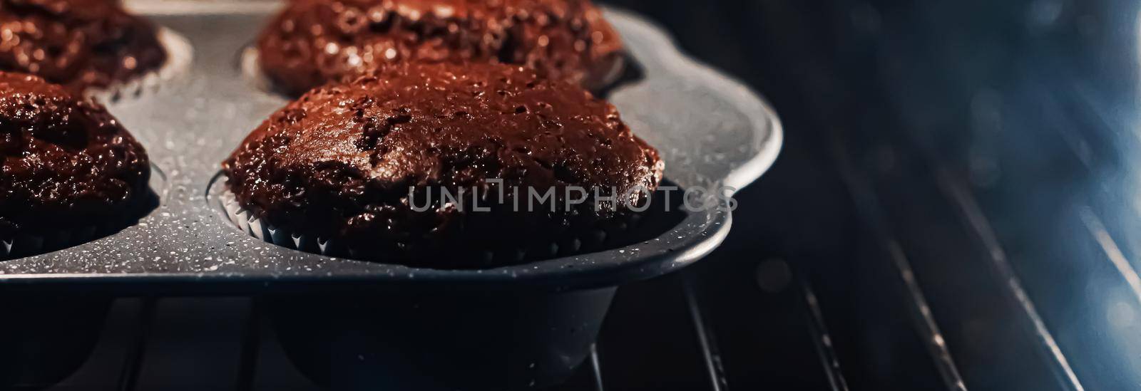 Chocolate muffins baking in the oven, homemade comfort food recipe concept