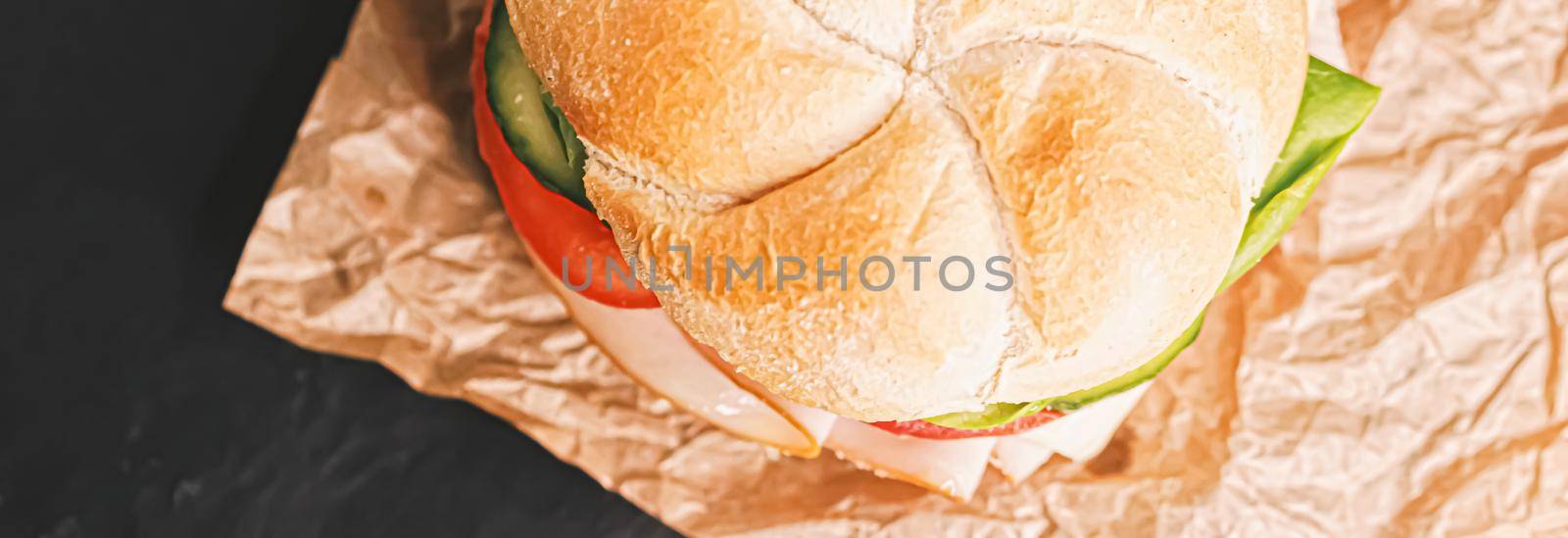 Sandwich with ham, cheese and fresh greens, take out comfort food closeup