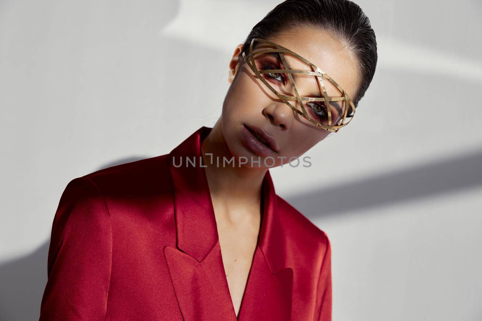 accessories on the face of a fashionable woman in a red jacket on a light background cropped view portrait. High quality photo