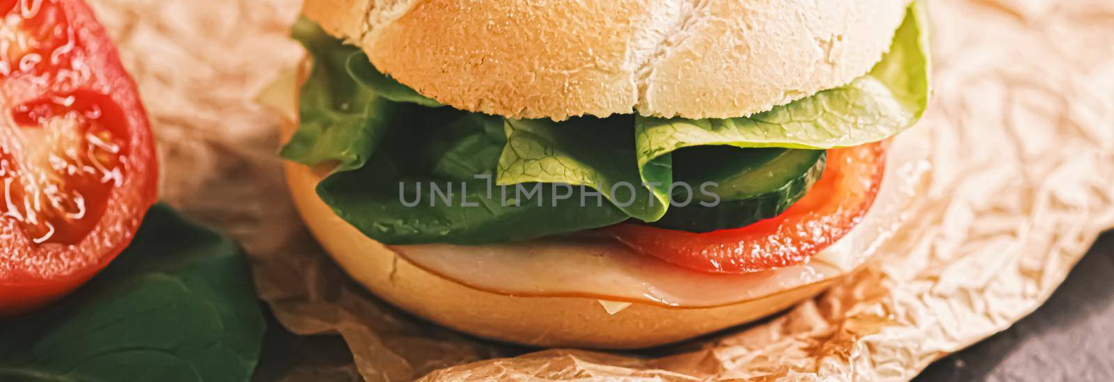 Sandwich with ham, cheese and fresh greens, take out comfort food closeup