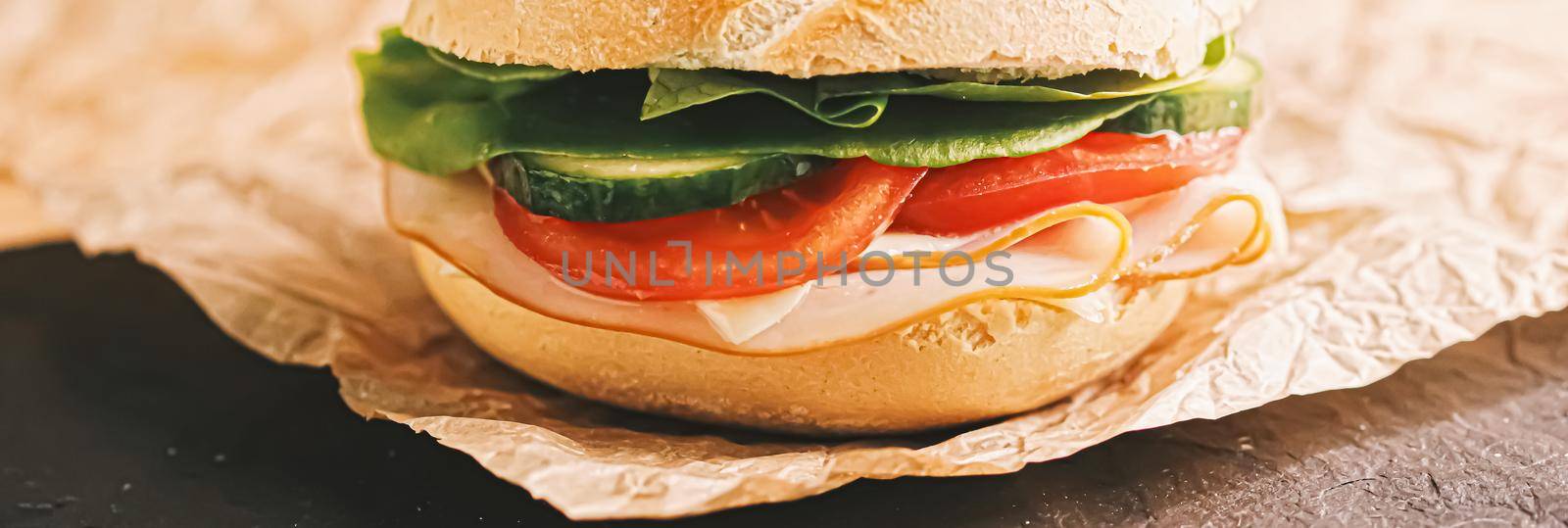 Sandwich with ham, cheese and fresh greens, take out comfort food closeup