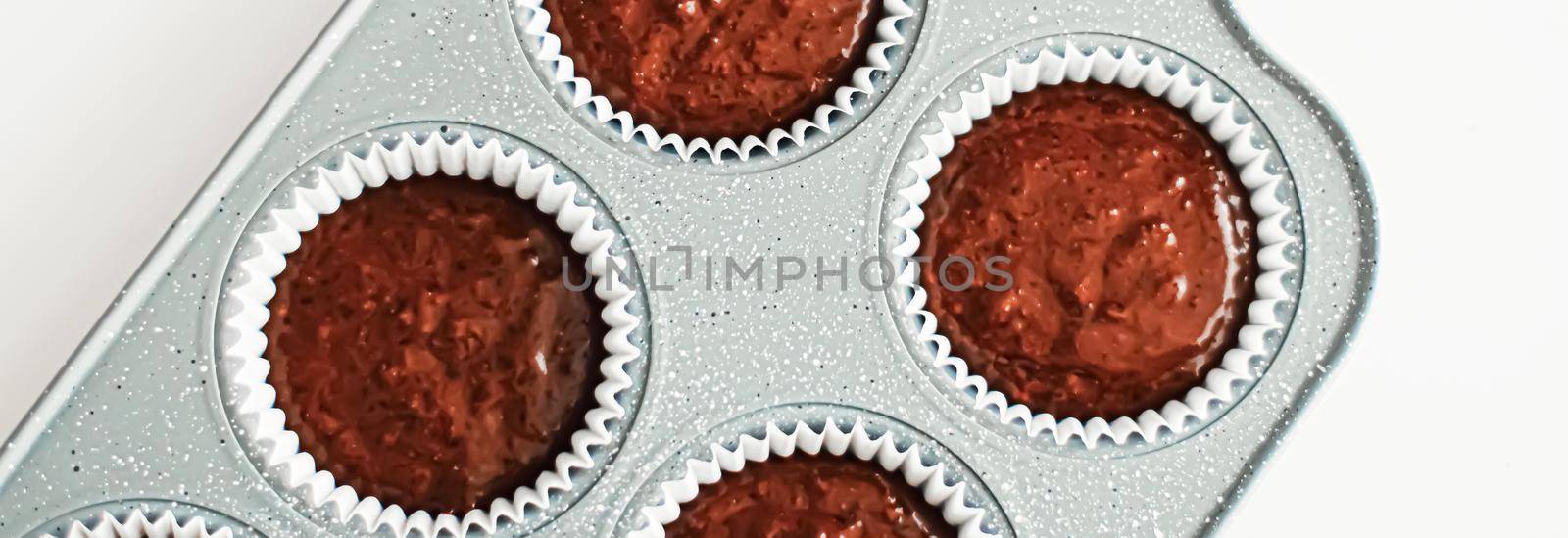 Chocolate muffin or cupcake batter in a pan ready to bake, homemade comfort food recipe concept