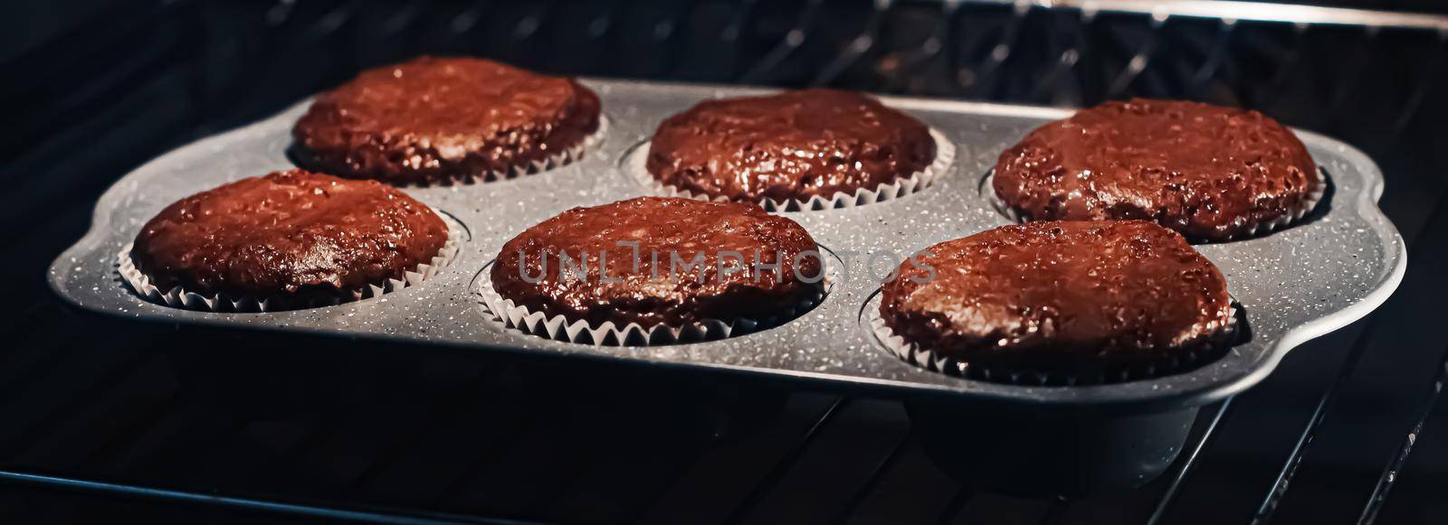Chocolate muffins baking in the oven, homemade comfort food recipe concept