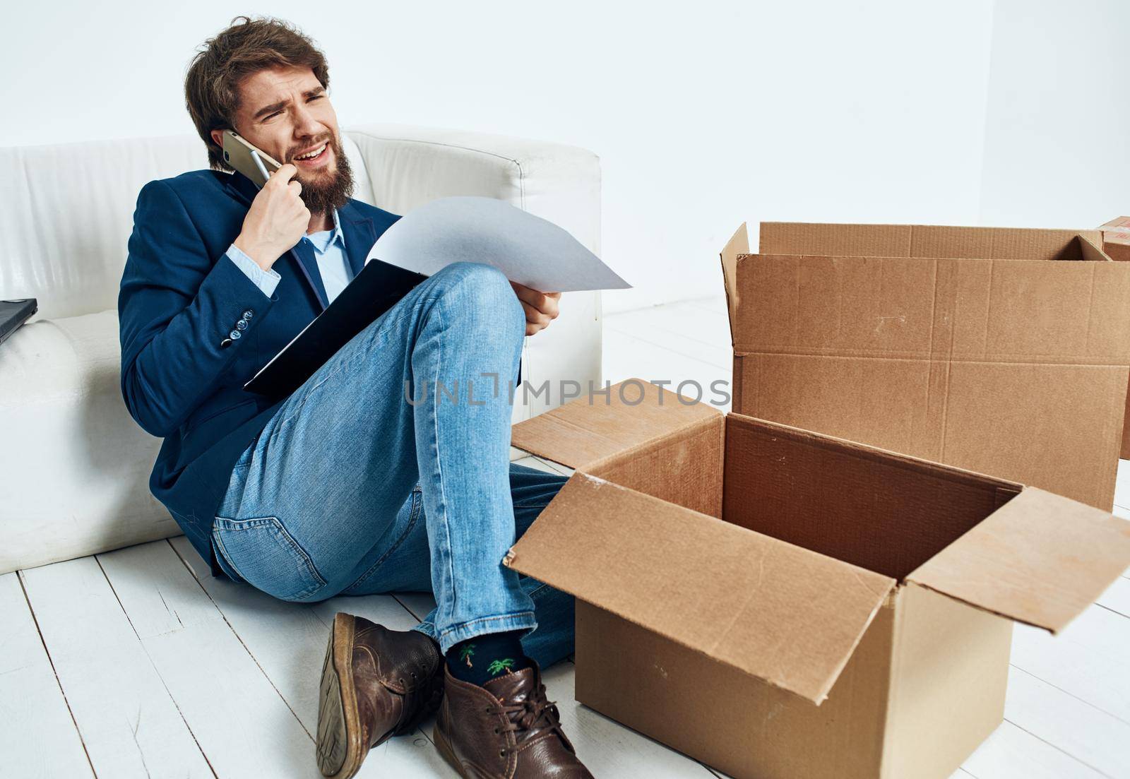 Man talking on the phone boxes with belongings moving unpacking official. High quality photo
