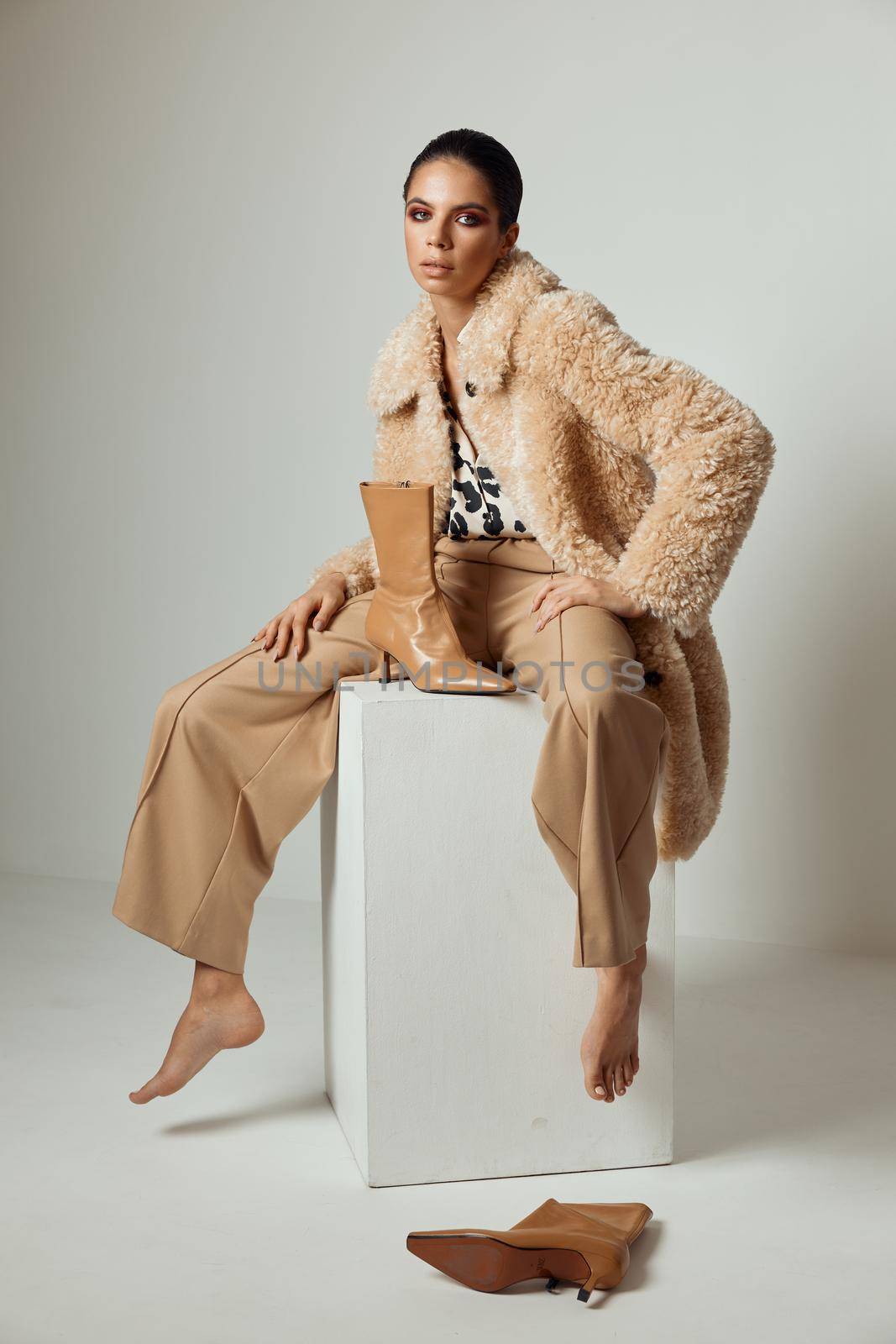 pretty brunette in a beige fur coat autumn style fashion barefoot. High quality photo
