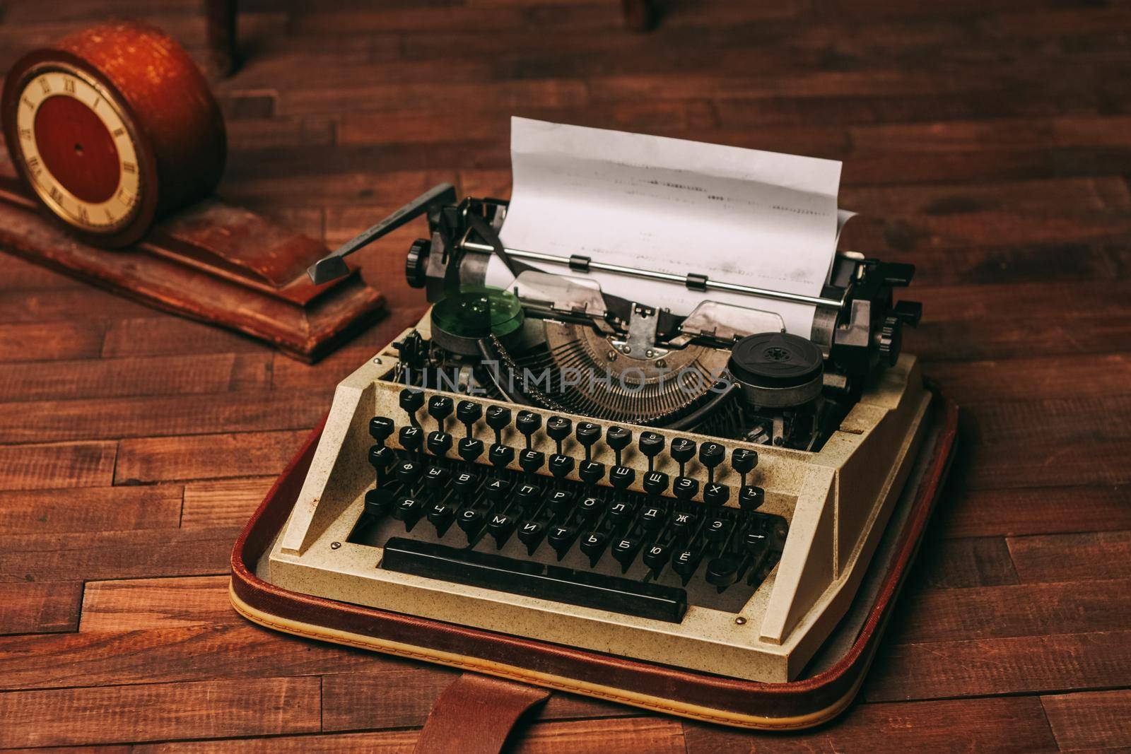 vintage typewriter with white paper stands on the floor indoors top view. High quality photo