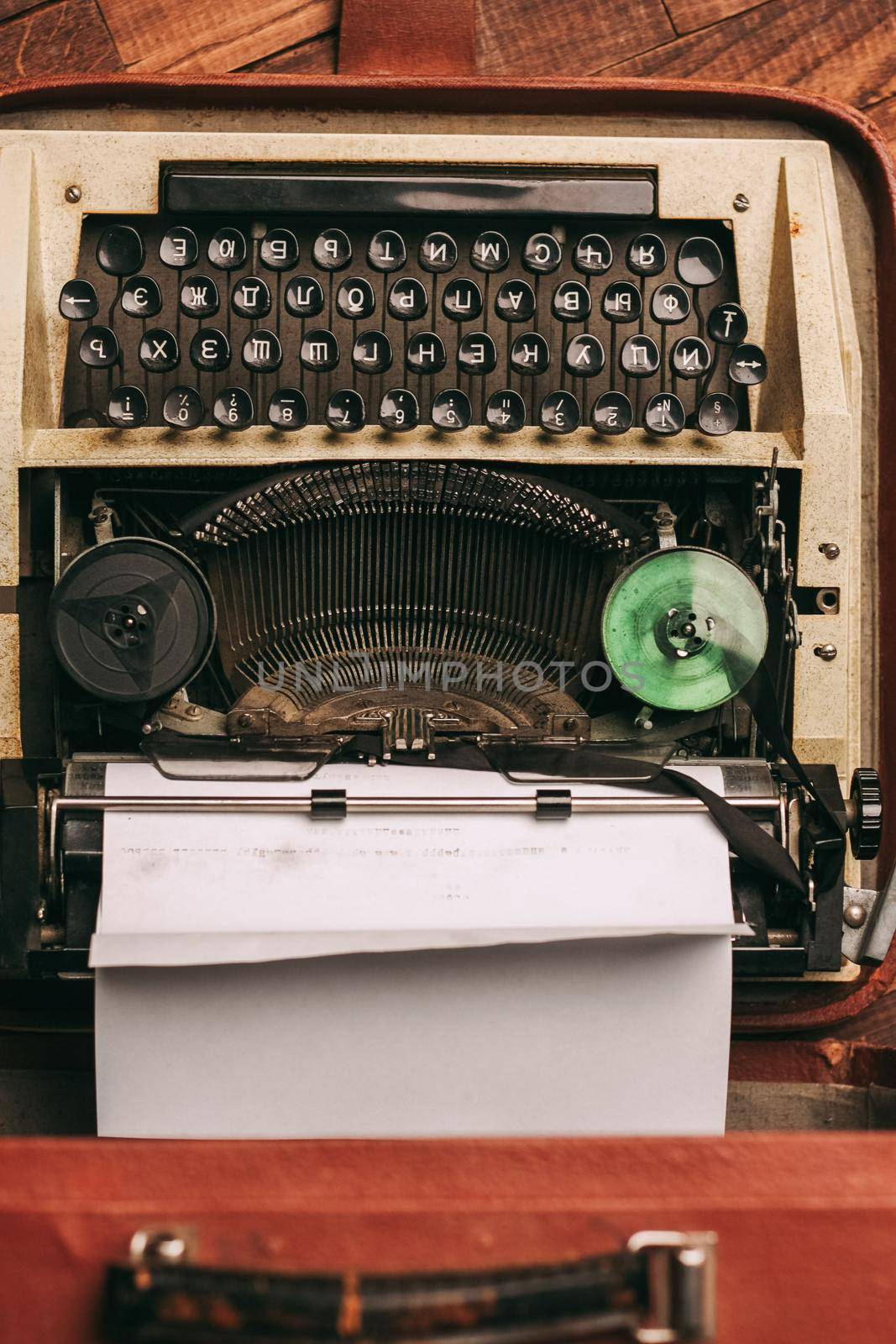 vintage typewriter with white paper stands on the floor indoors top view. High quality photo