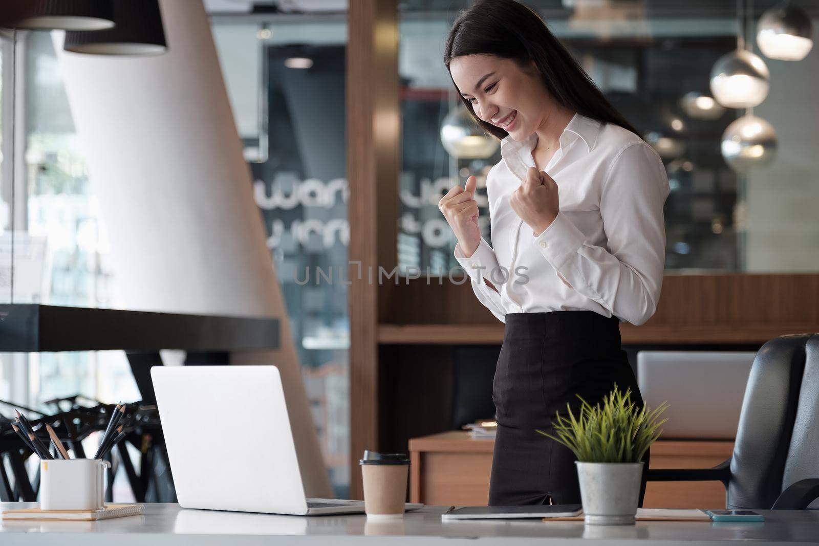 Business Winner - Happy excited successful businesswoman triumphing in office