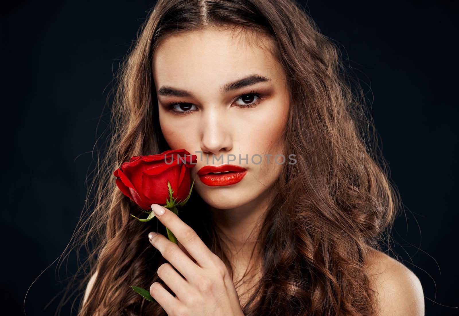 Romantic woman on a black background with a red flower. High quality photo