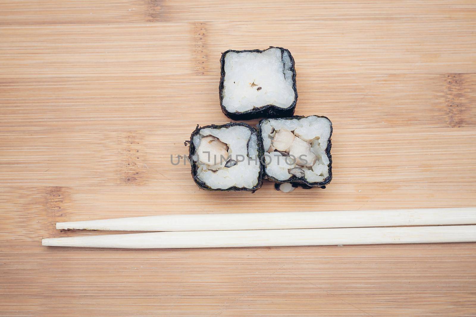 sushi rolls chopsticks wooden board top view. High quality photo