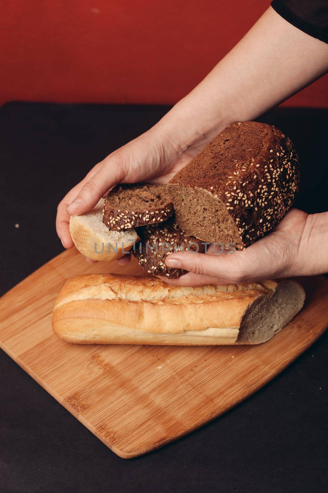 sliced white baguette and a loaf of rye bread on a board by SHOTPRIME