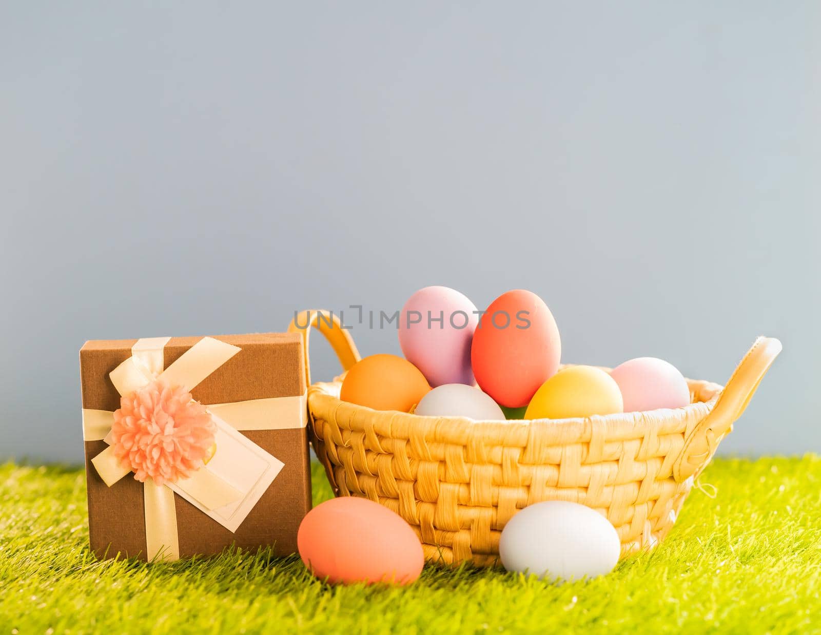 Easter eggs in the basket on green grass by stoonn