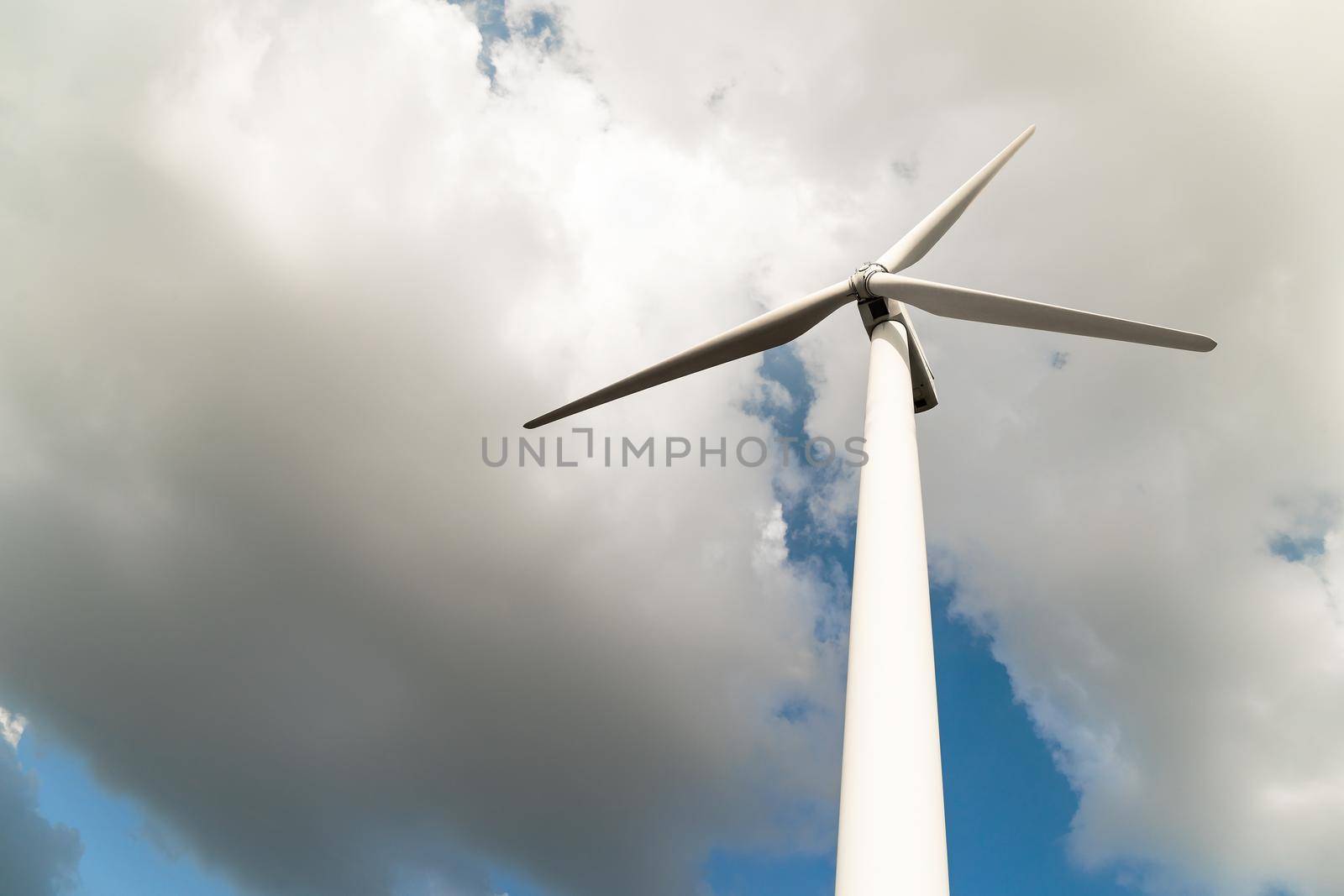 Close up Wind turbine  generators against a cloudy blue sky