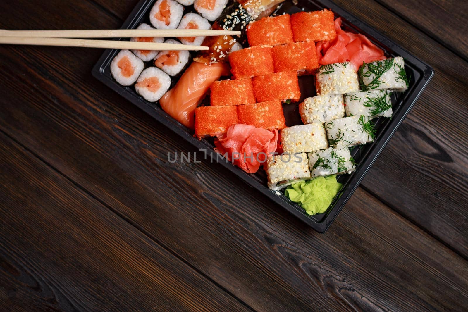 sushi rolls with seafood on a wooden table and chopsticks. High quality photo