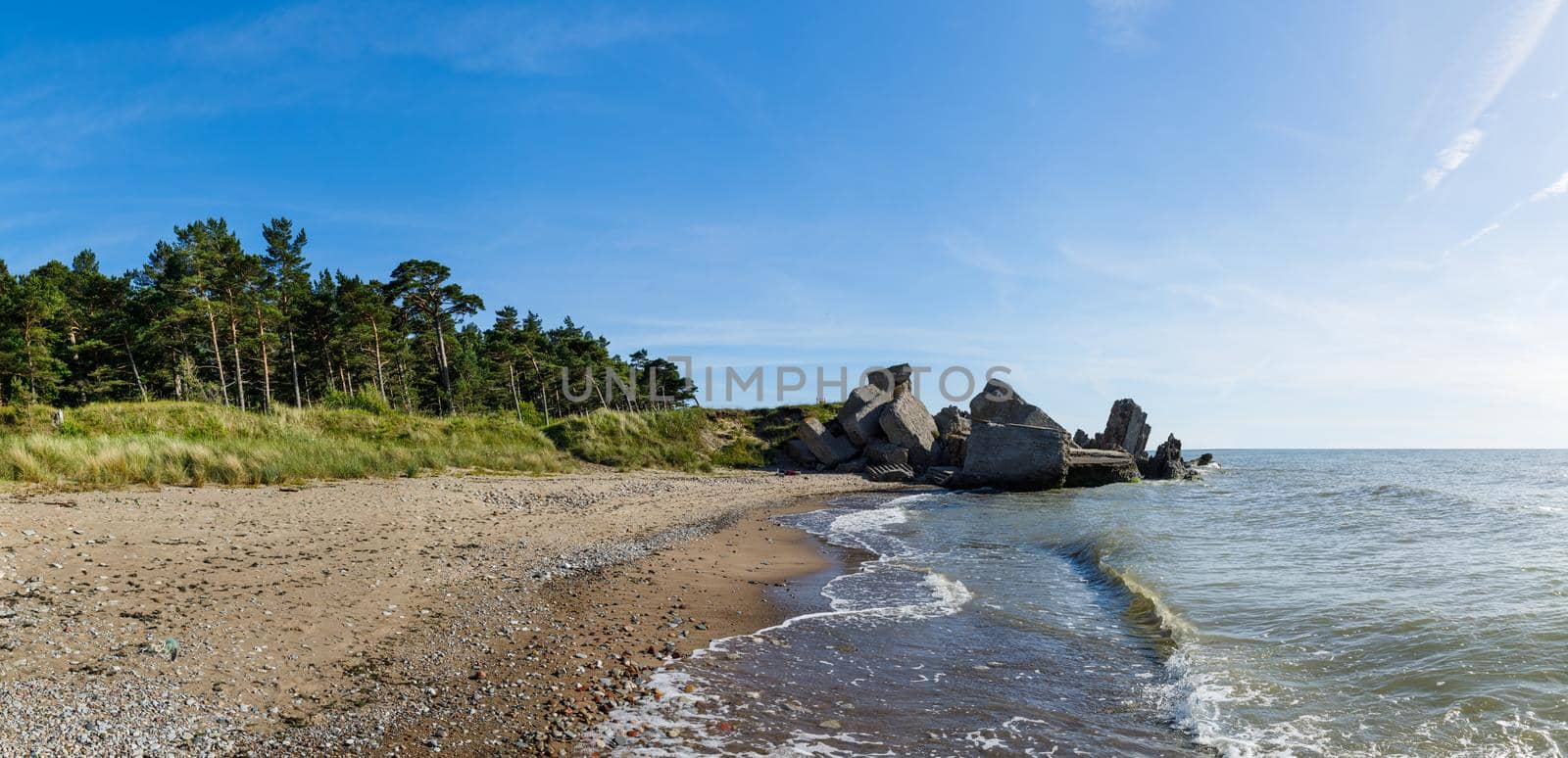 Demolished military fortifications in Liepaja, Latvia. Baltic sea coastline with pine trees and clouds. Classical Baltic beach landscape.