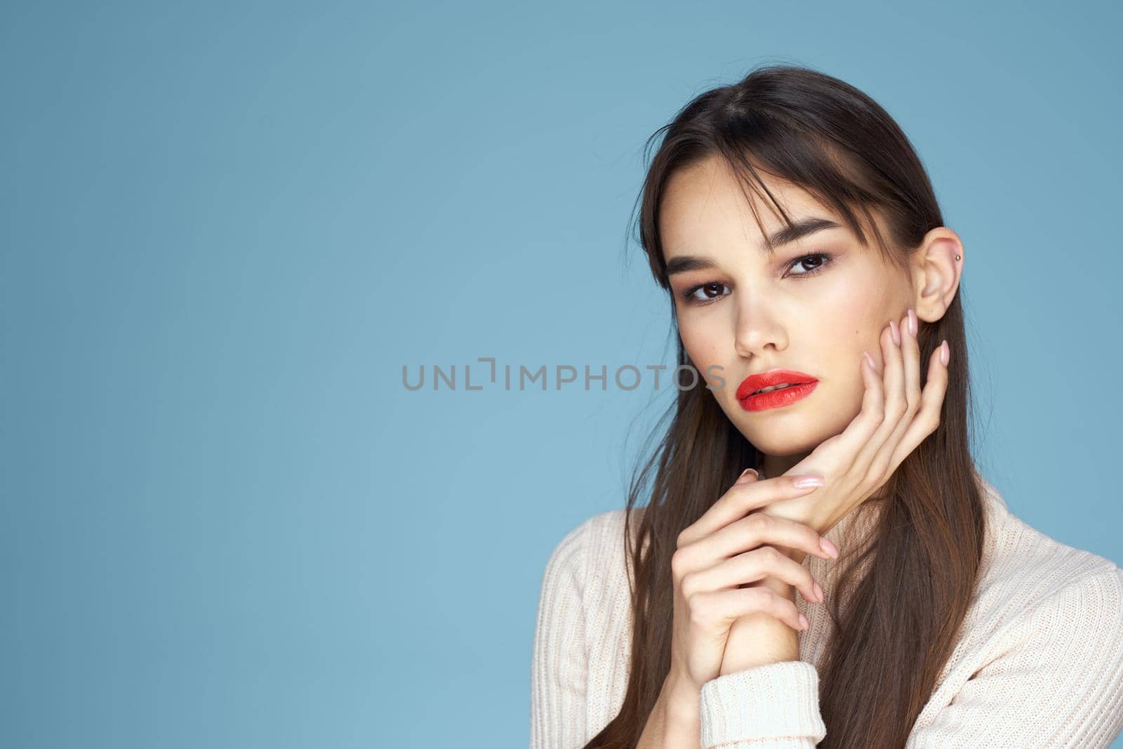 Brunette in white sweater red lips charm cropped view blue background. High quality photo
