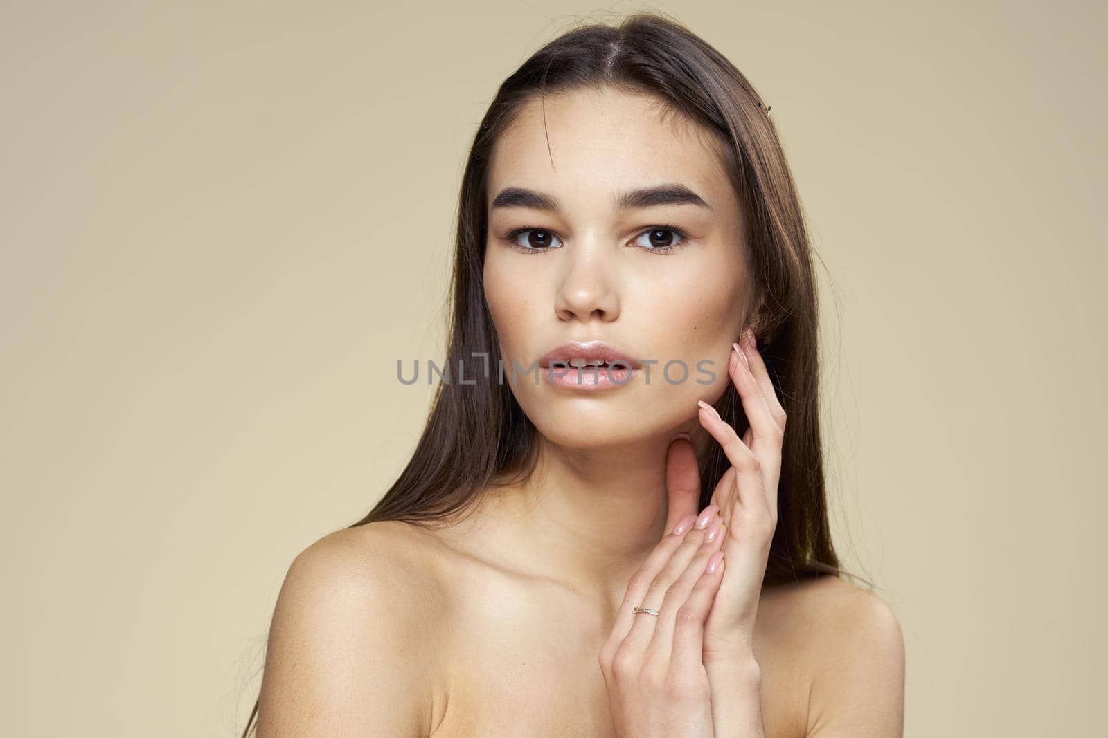 Pretty woman naked shoulders long hair body care beige background. High quality photo