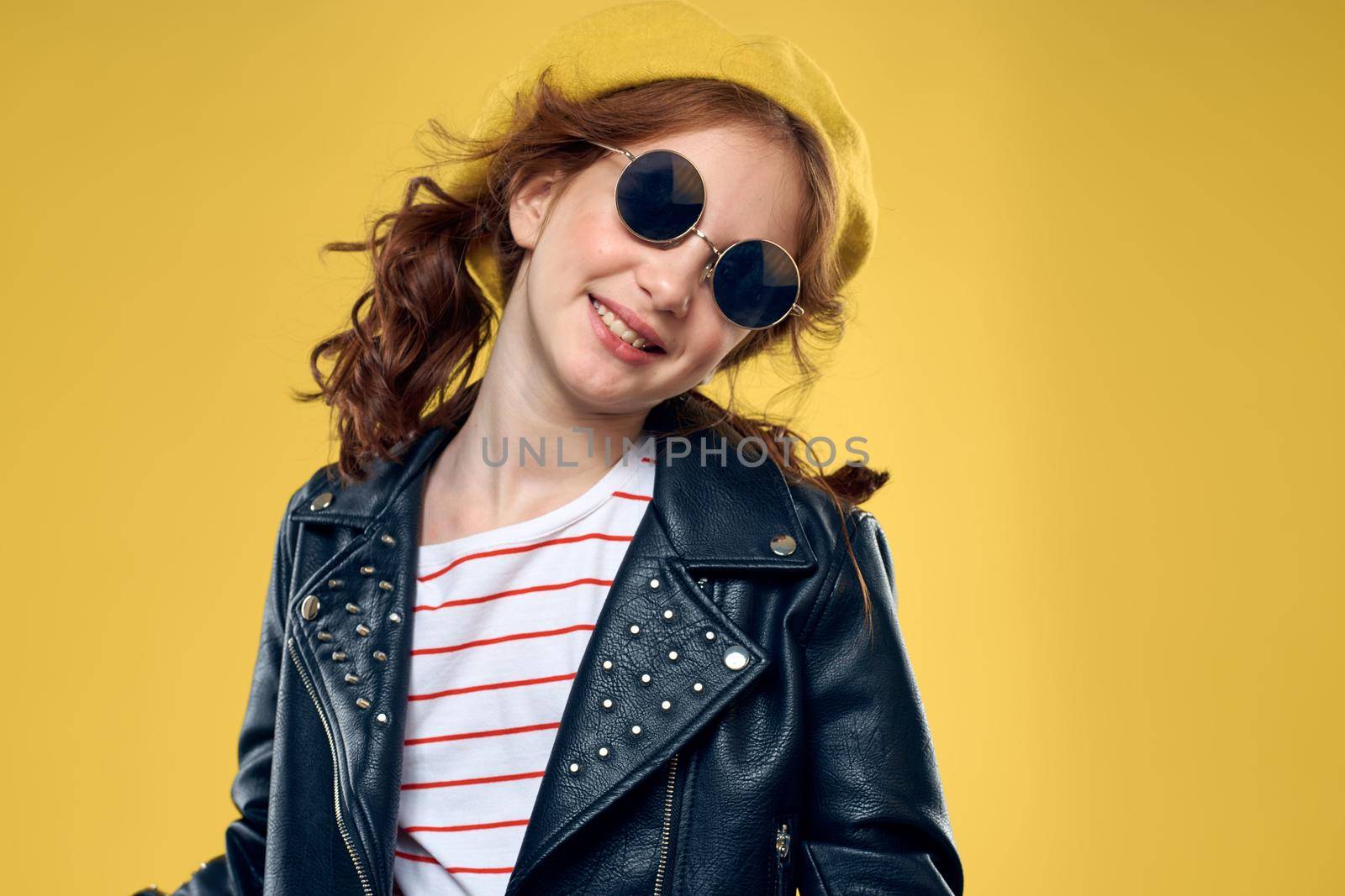 Girl in a yellow hat dark glasses fashionable clothes studio lifestyle childhood. High quality photo