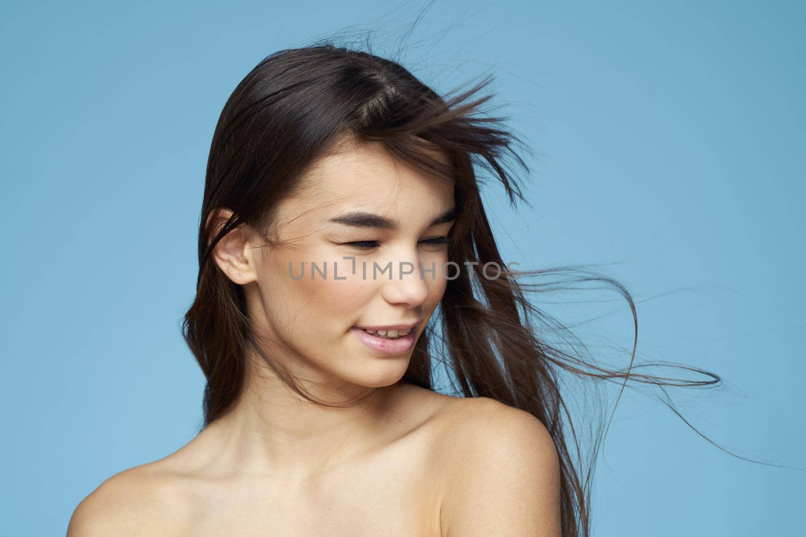 Pretty woman naked shoulders hair care close-up bank blue background by SHOTPRIME