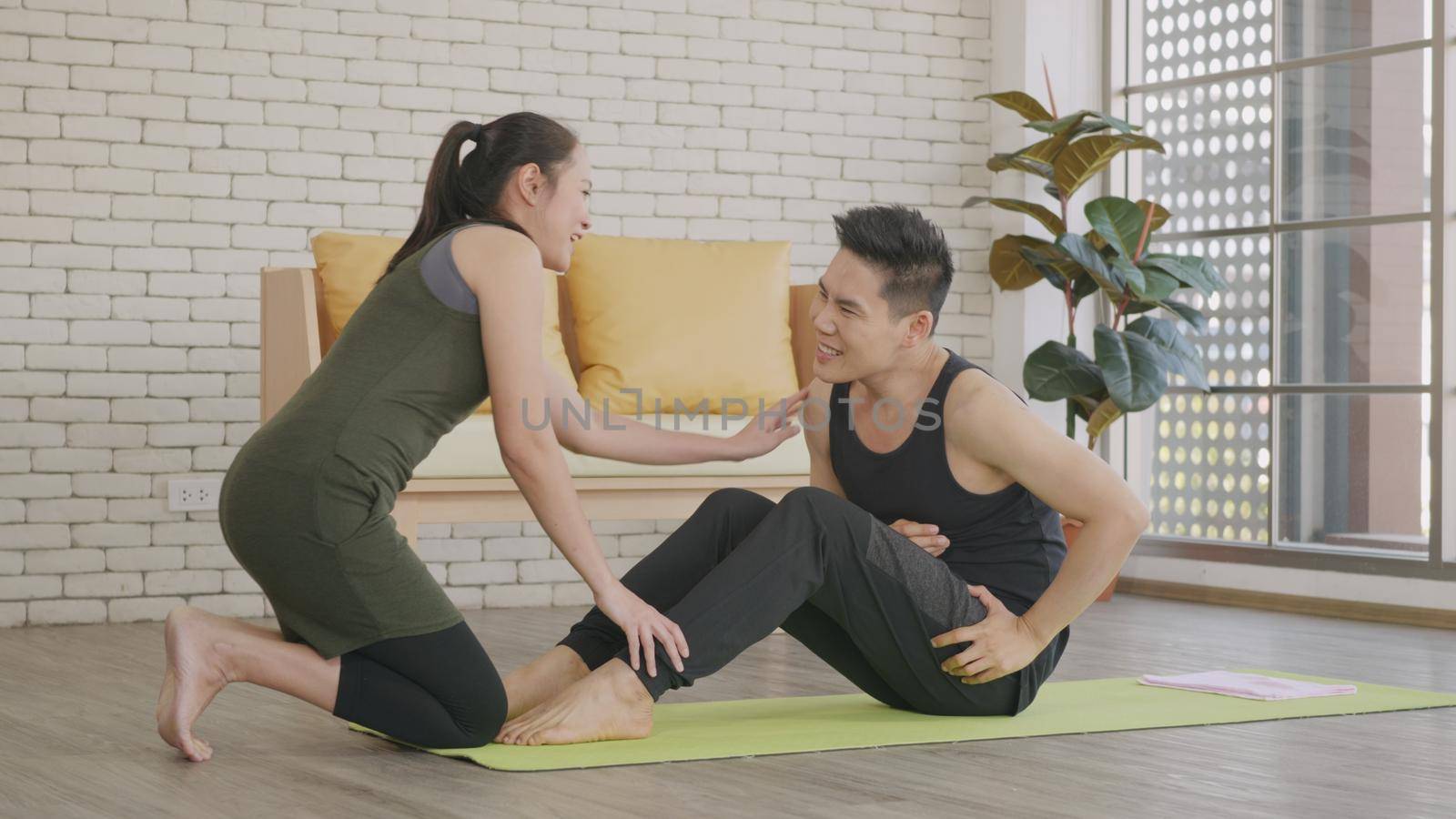 family couple husband and wife healthy trainer workout home in the living room by Sorapop