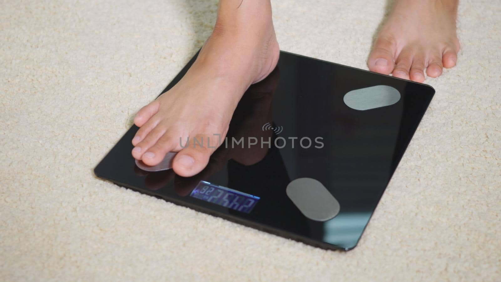 Asian young woman leg stepping standing on floor electric scales, female working out at home in living room, female stand on digital weighing machine. Healthy weight loss control concept, slow motion