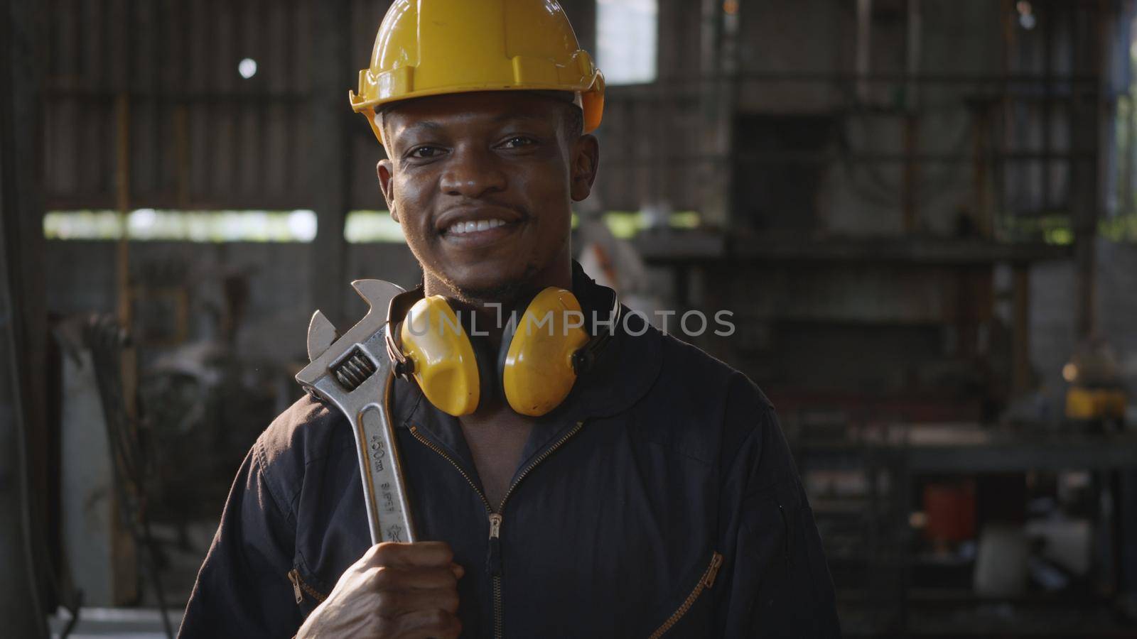 Engineer standing holding wrench on his shoulder at work in industry by Sorapop